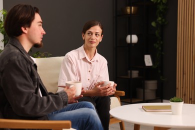 Photo of Woman and man talking while having tea at home