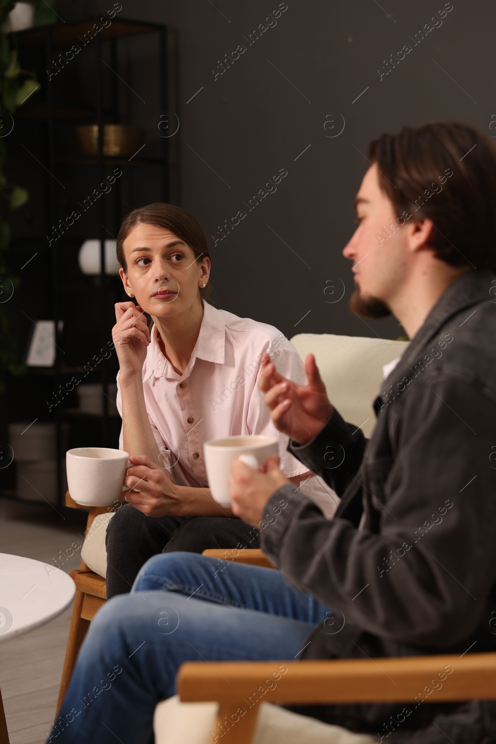 Woman and man talking while having tea at home Photo of Woman and man talking while having tea at home