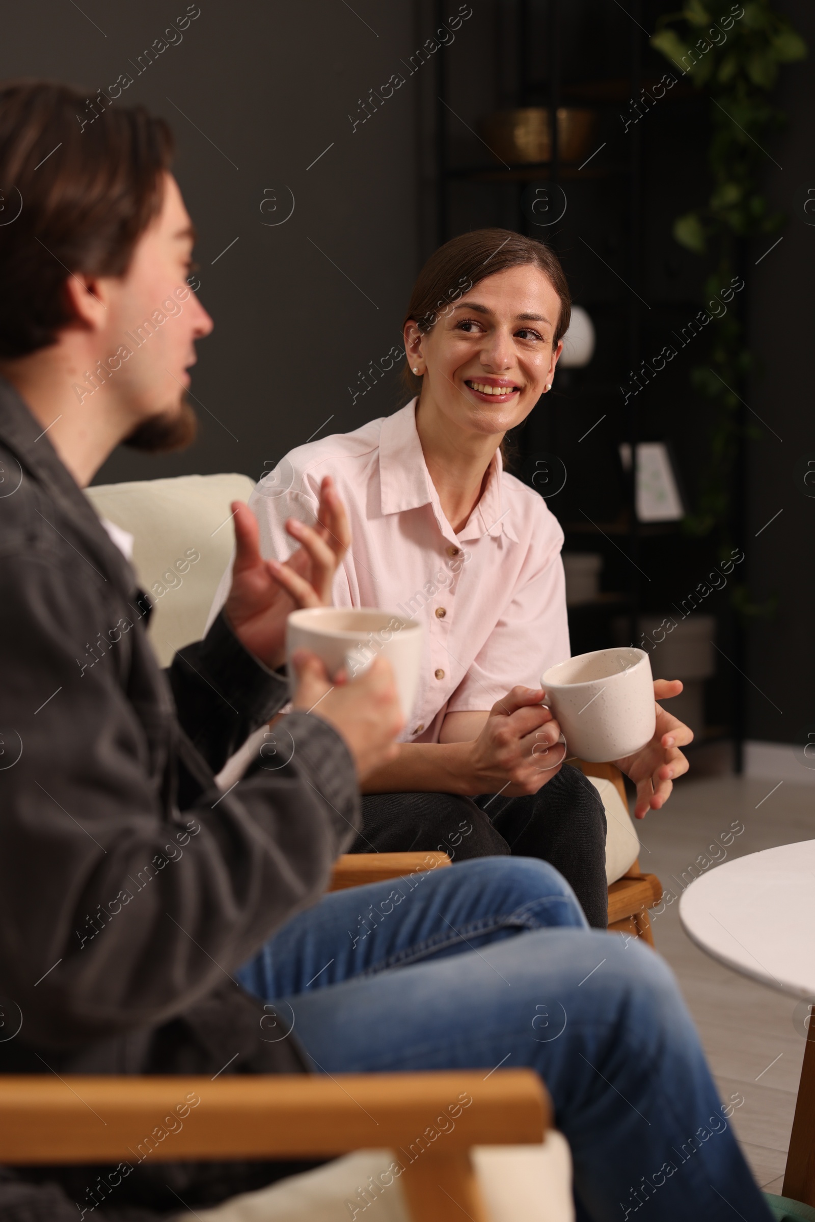 Photo of Woman and man talking while having tea at home