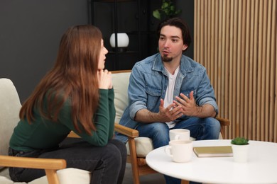Photo of Woman and man talking while having tea at home