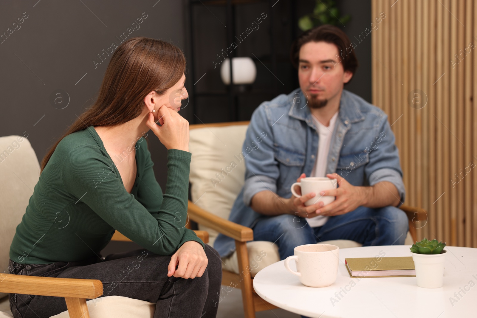 Photo of Woman and man talking while having tea at home