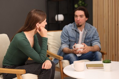 Photo of Woman and man talking while having tea at home