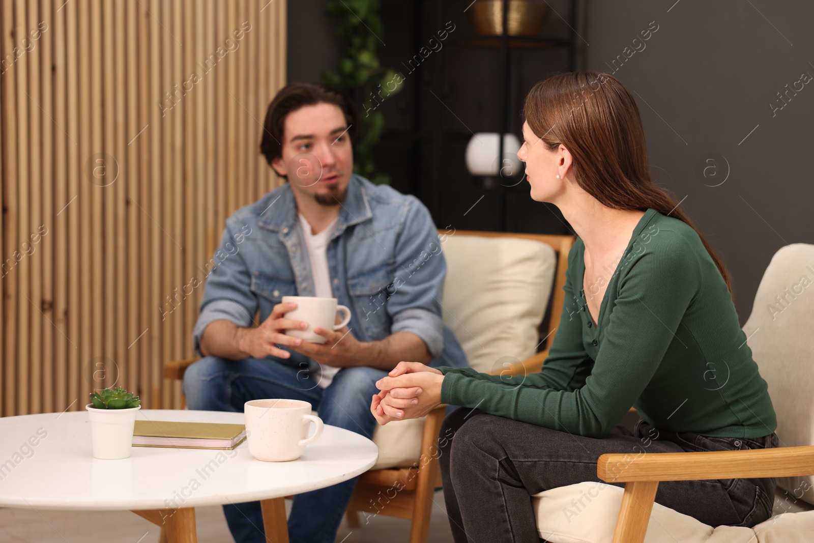 Woman and man talking while having tea at home Photo of Woman and man talking while having tea at home