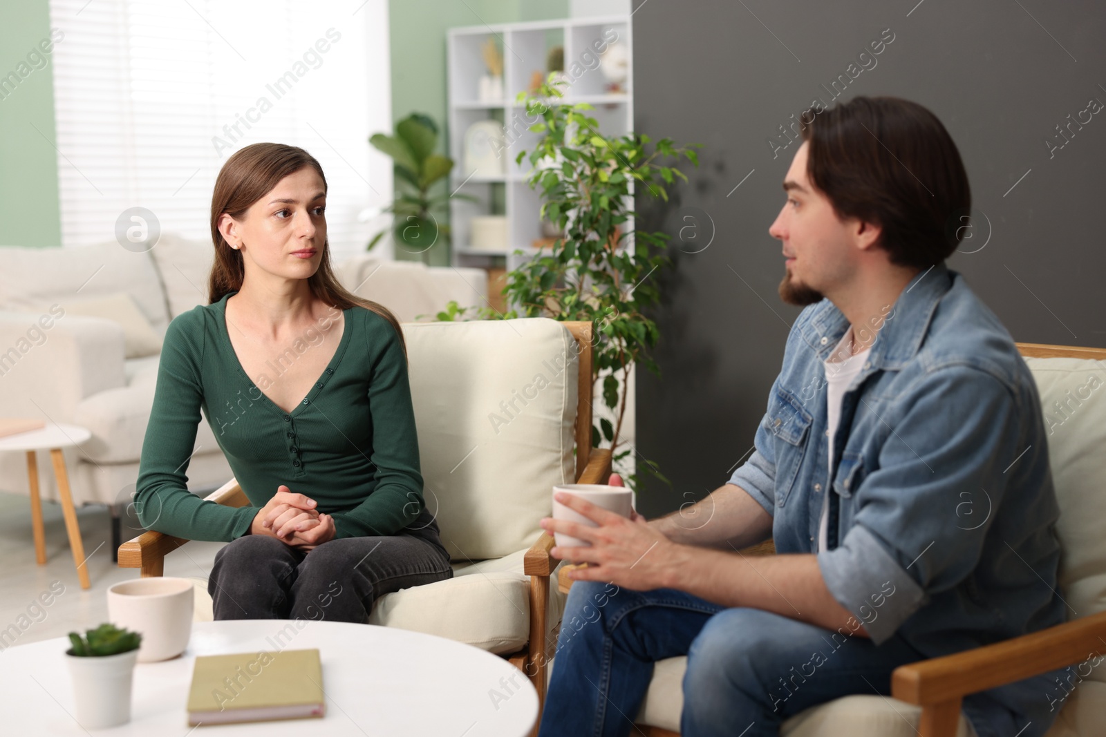 Photo of Woman and man talking while having tea at home