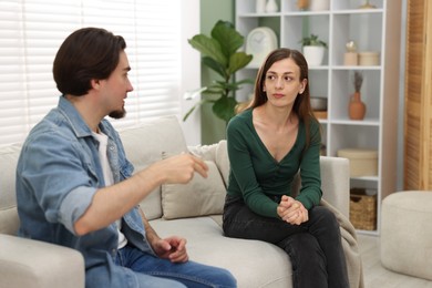 Photo of Woman and man talking on sofa at home