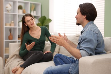 Photo of Woman and man talking on sofa at home