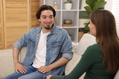 Photo of Woman and man talking on sofa at home