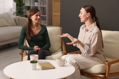 Photo of Friends talking while having tea at home