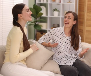 Photo of Friends having conversation on sofa at home