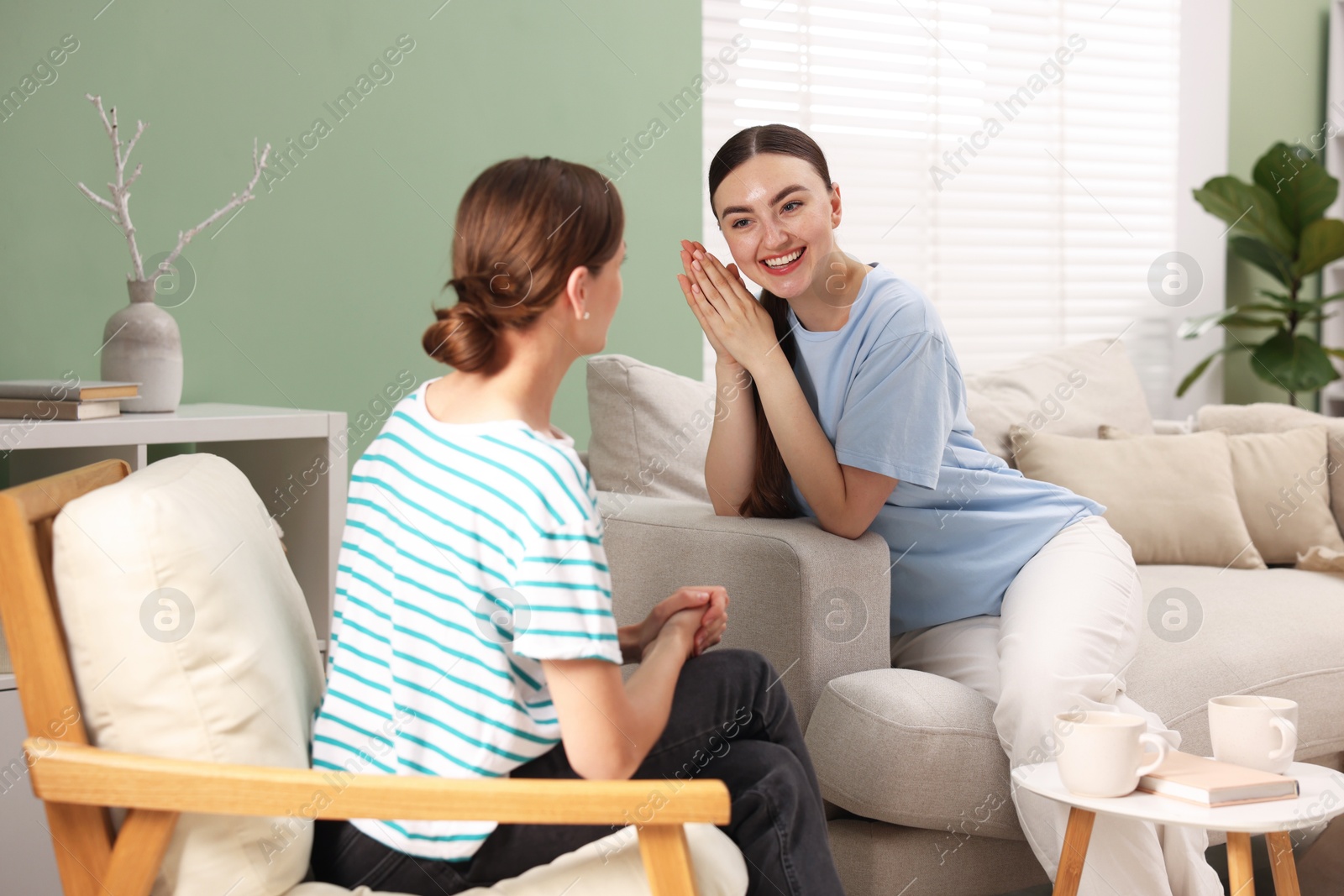 Photo of Friends talking while having tea at home