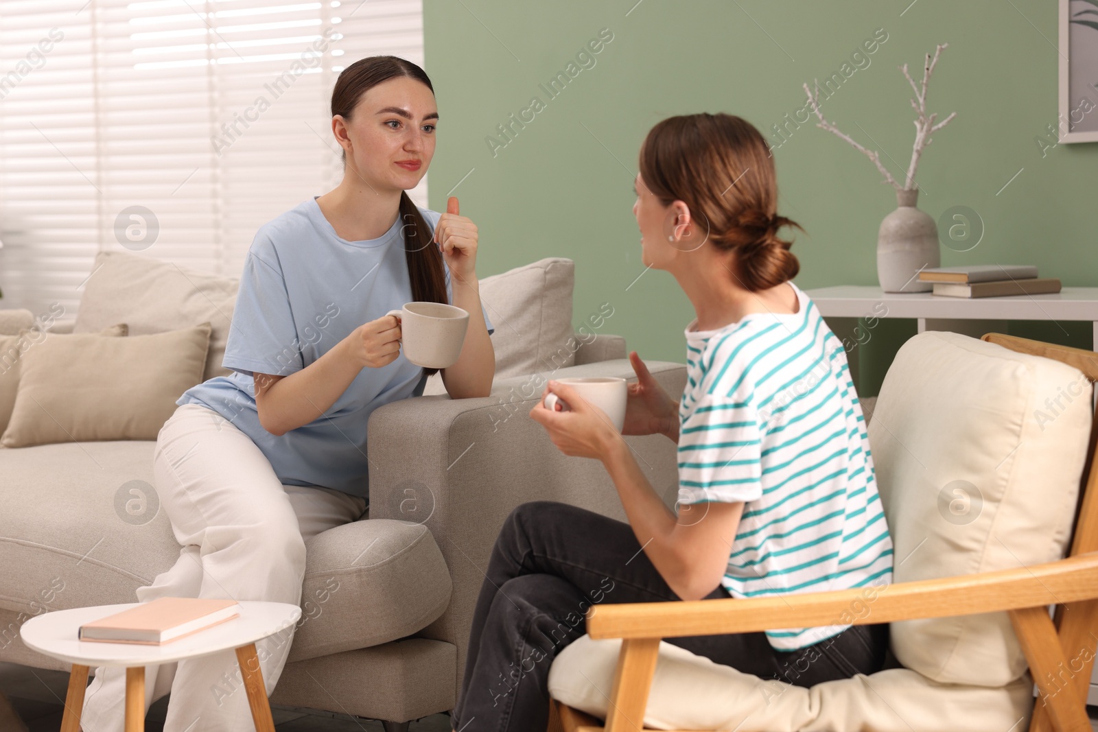 Photo of Friends talking while having tea at home