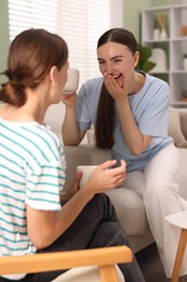 Photo of Friends talking while having tea at home