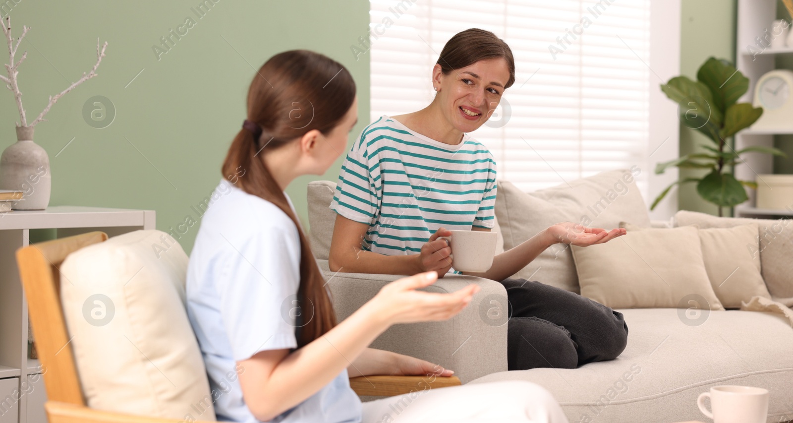 Photo of Friends talking while having tea at home