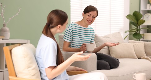 Photo of Friends talking while having tea at home