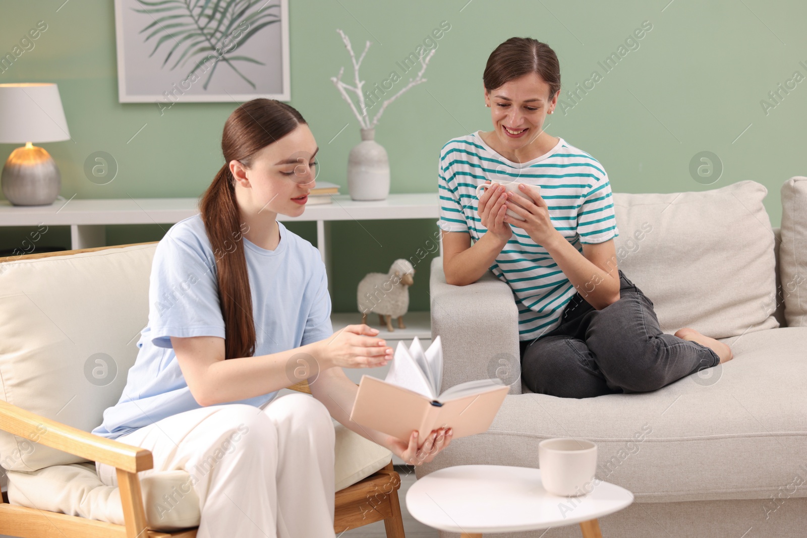 Photo of Friends discussing book during tea time at home