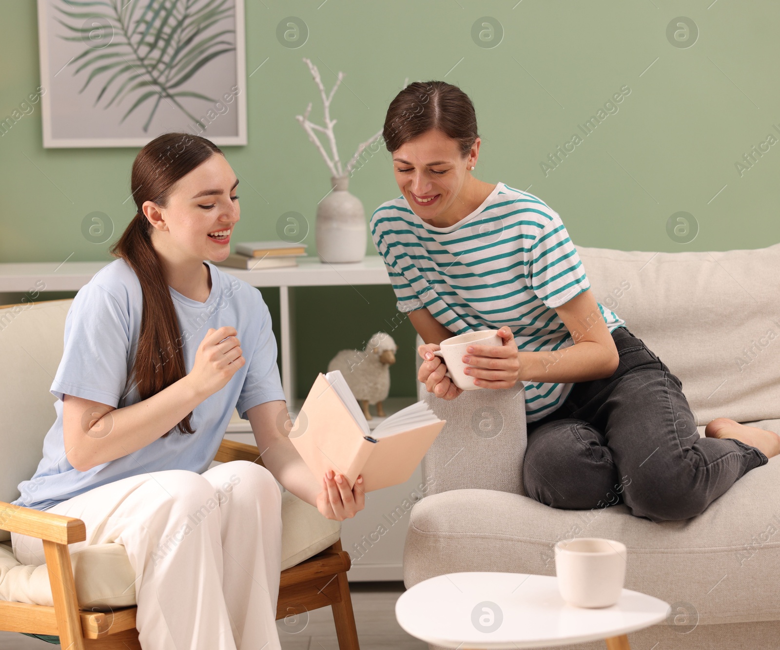 Photo of Friends discussing book during tea time at home