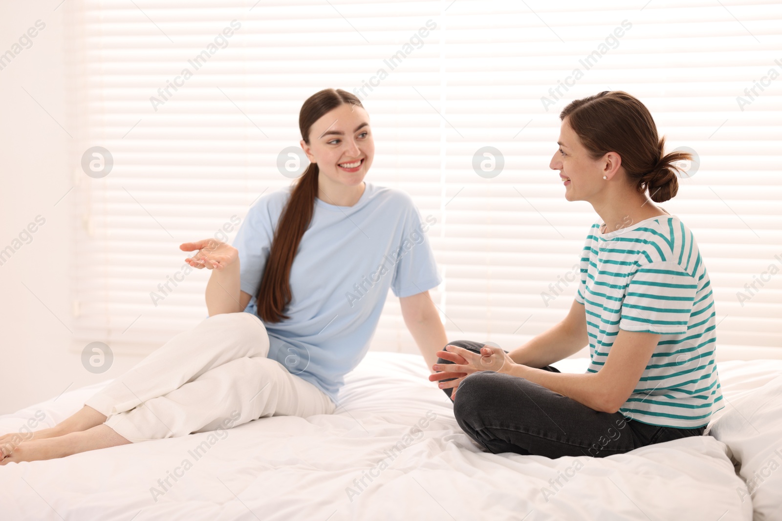 Friends gossiping during sleepover on bed at home Photo of Friends gossiping during sleepover on bed at home