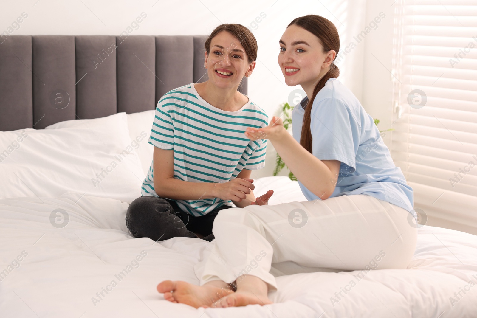 Friends gossiping during sleepover on bed at home Photo of Friends gossiping during sleepover on bed at home