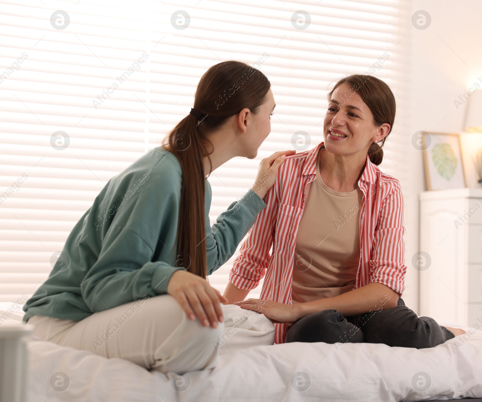 Friends gossiping during sleepover on bed at home Photo of Friends gossiping during sleepover on bed at home