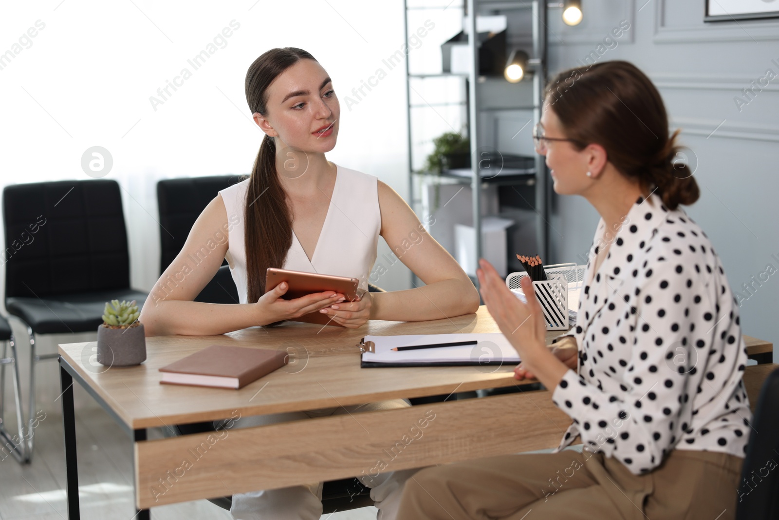 Photo of Coworkers discussing project together at desk in office