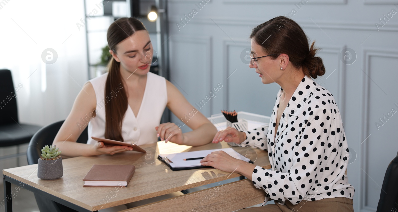 Photo of Coworkers discussing project together at desk in office