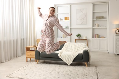 Photo of Happy woman in pyjama jumping at home