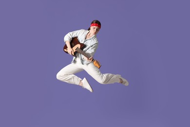 Photo of Woman with guitar jumping on purple background