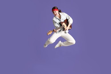 Photo of Woman with guitar jumping on purple background