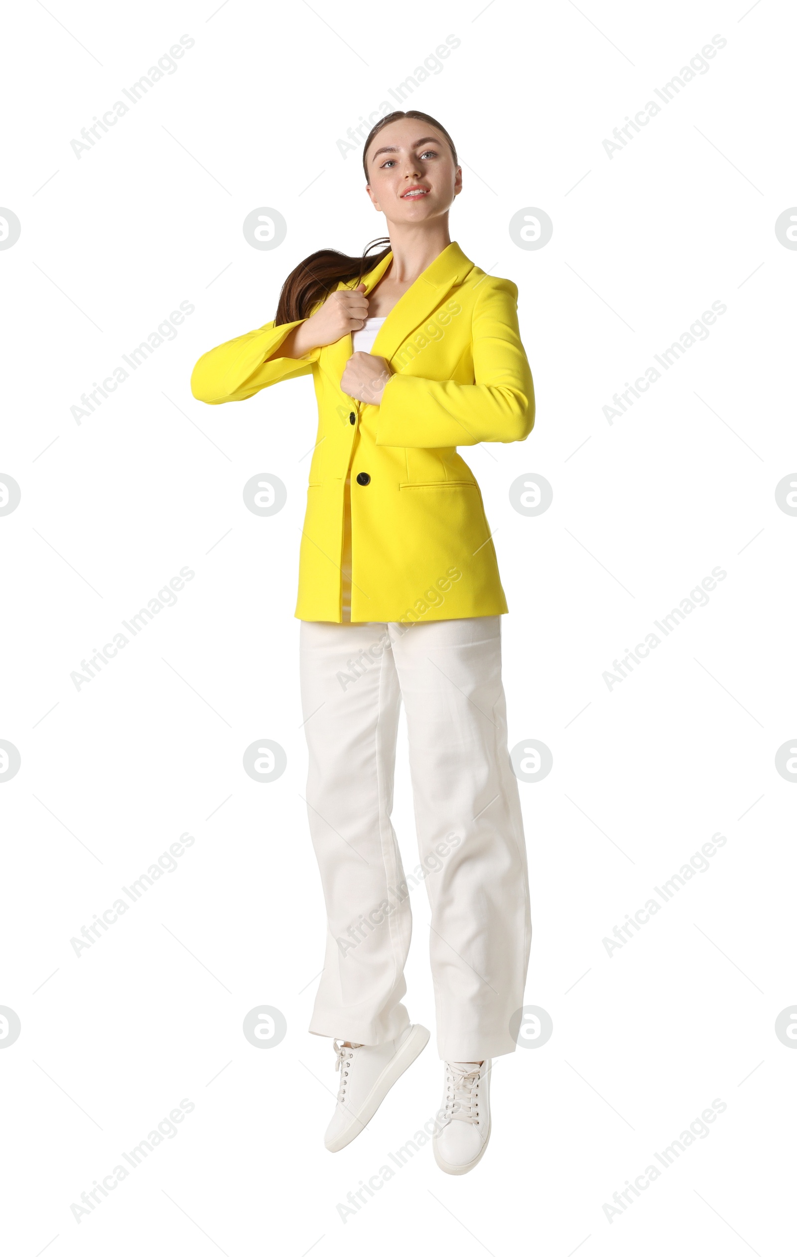 Woman in yellow jacket jumping on white background Photo of Woman in yellow jacket jumping on white background