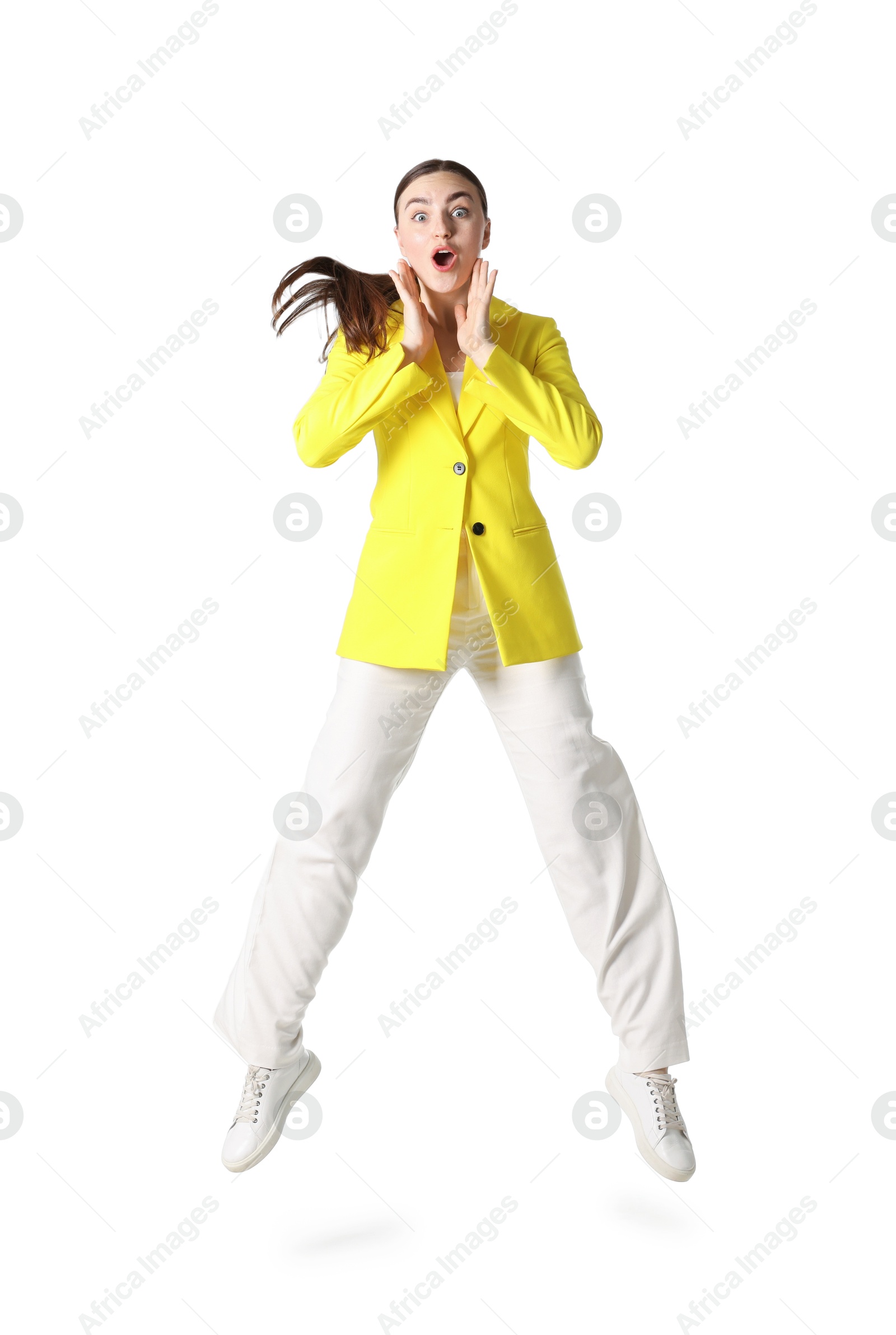 Woman in yellow jacket jumping on white background Photo of Woman in yellow jacket jumping on white background
