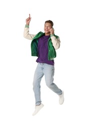 Photo of Man jumping while talking on smartphone against white background