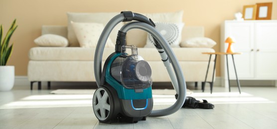 Photo of One vacuum cleaner on floor indoors. Household appliance