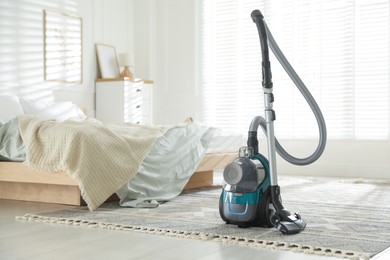 Photo of One vacuum cleaner on floor in bedroom. Household appliance