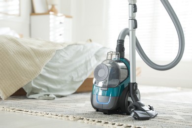 Photo of One vacuum cleaner on floor in bedroom. Household appliance