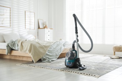 Photo of One vacuum cleaner on floor in bedroom. Household appliance