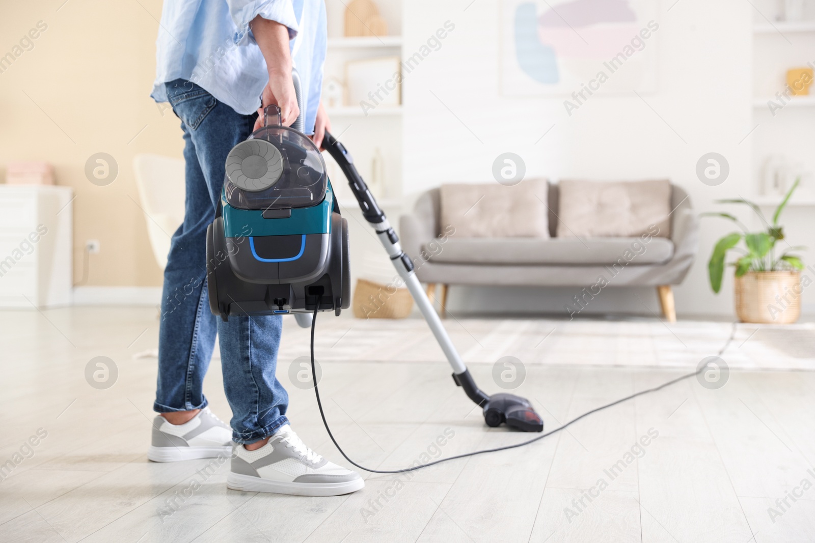 Man cleaning floor with vacuum cleaner at home, closeup. Space for text Photo of Man cleaning floor with vacuum cleaner at home, closeup. Space for text
