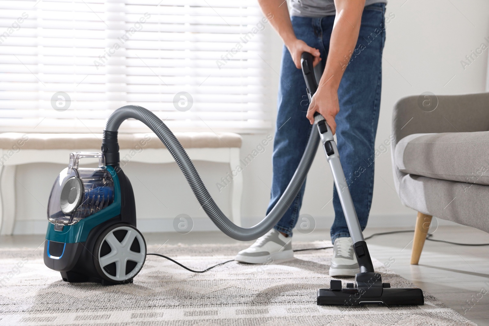Man cleaning carpet with vacuum cleaner at home, closeup Photo of Man cleaning carpet with vacuum cleaner at home, closeup