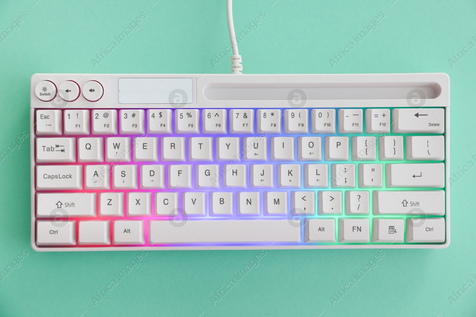 Photo of Modern computer keyboard with RGB lighting on turquoise background, top view