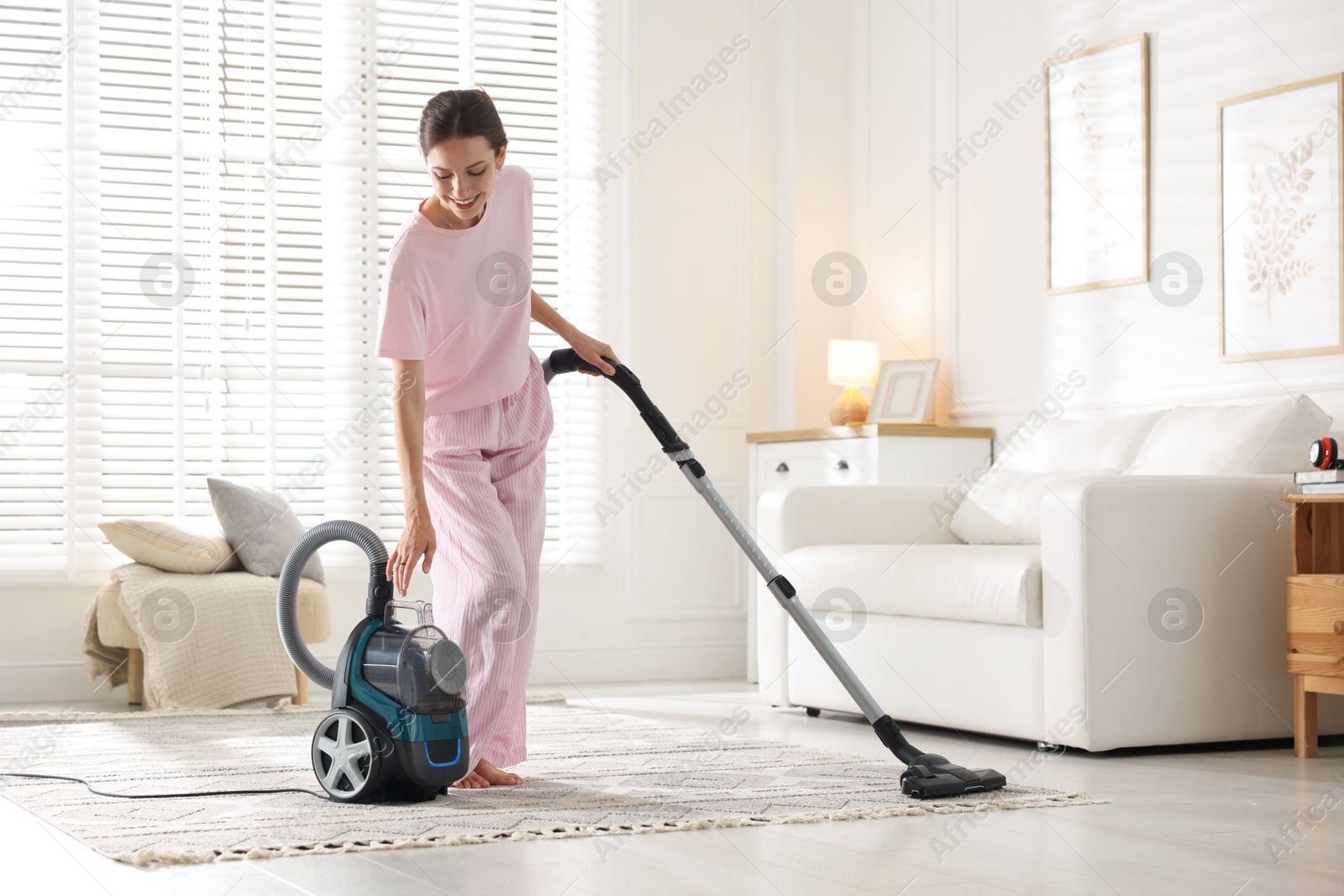 Woman cleaning carpet with vacuum cleaner at home Photo of Woman cleaning carpet with vacuum cleaner at home
