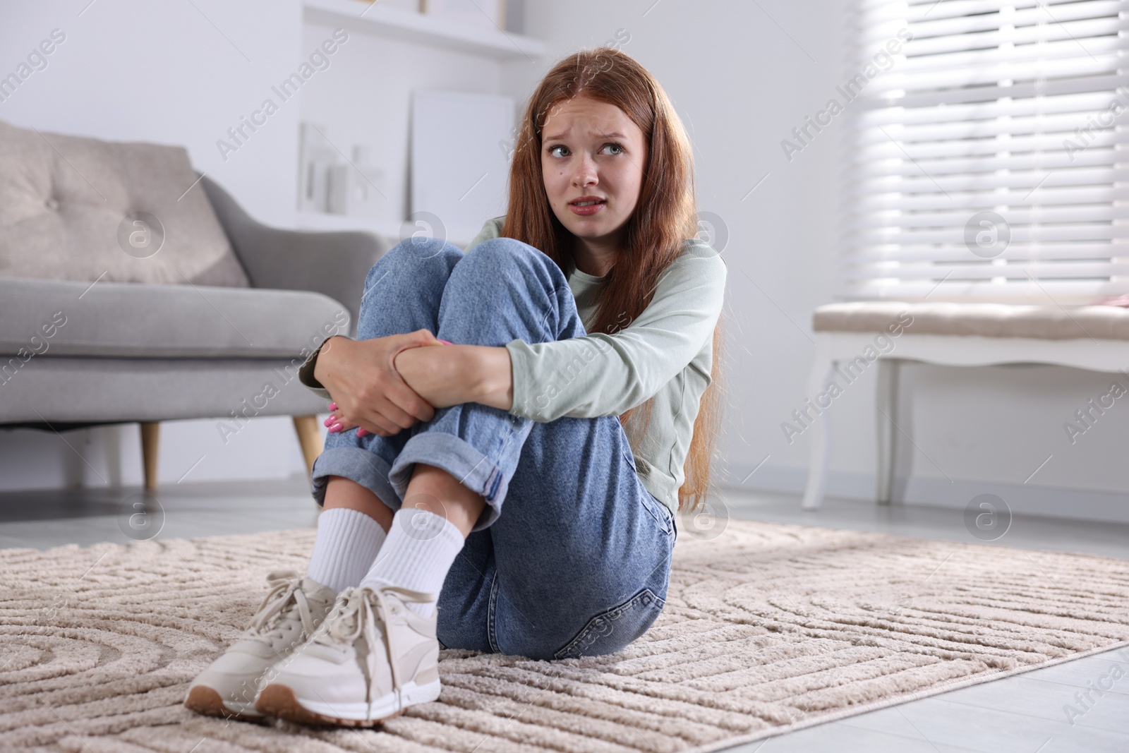 Teenage girl suffering from panic attack on floor at home Photo of Teenage girl suffering from panic attack on floor at home