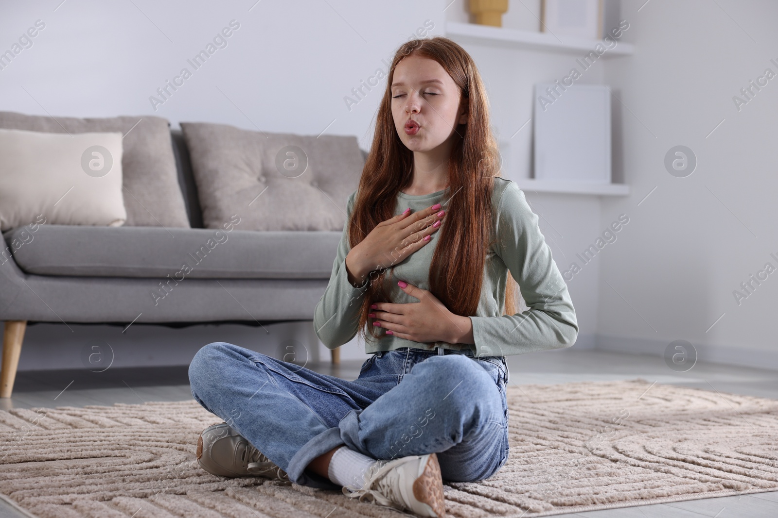 Photo of Teenage girl deep breathing on floor at home. Way to stop panic attack