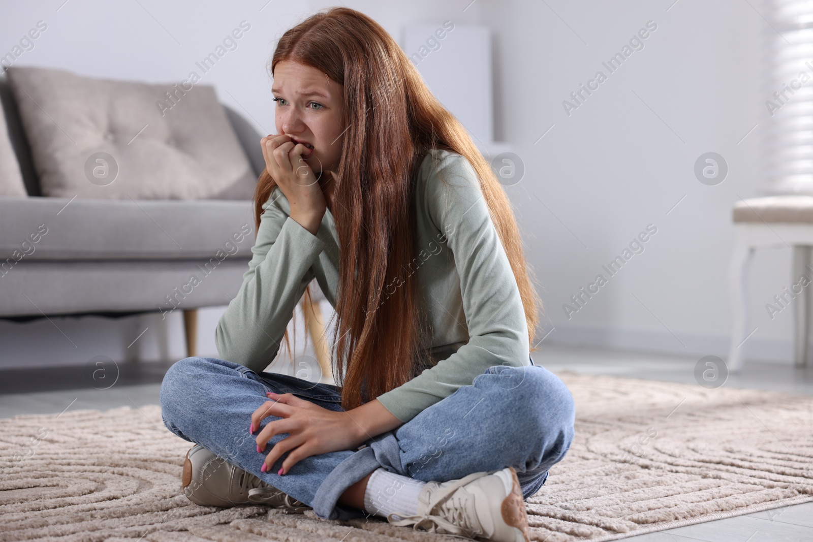 Teenage girl suffering from panic attack on floor at home Photo of Teenage girl suffering from panic attack on floor at home