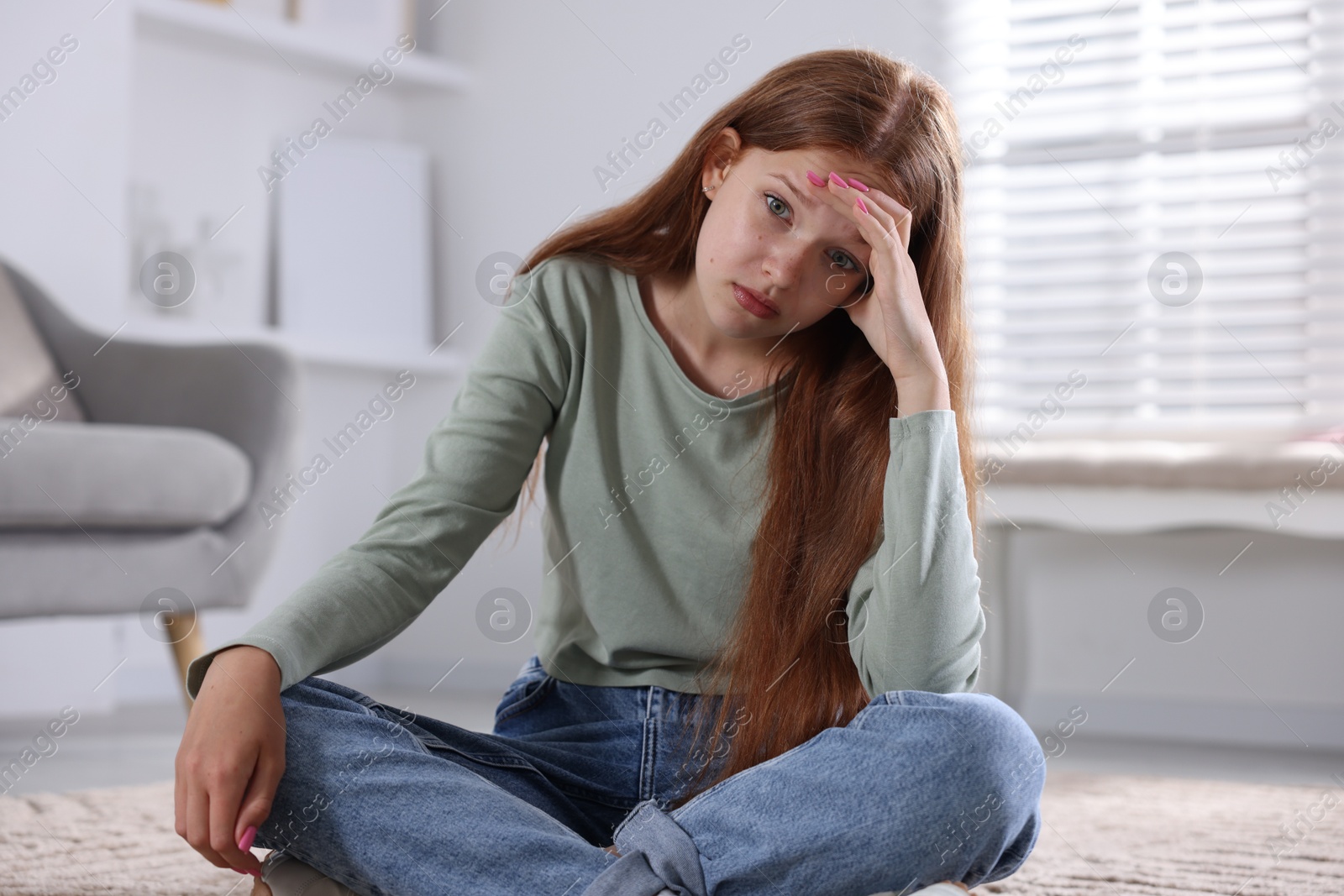 Teenage girl suffering from panic attack on floor at home Photo of Teenage girl suffering from panic attack on floor at home