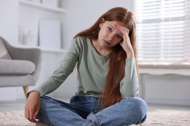 Photo of Teenage girl suffering from panic attack on floor at home