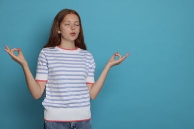 Photo of Teenage girl meditating on light blue background, space for text. Way to stop panic attack