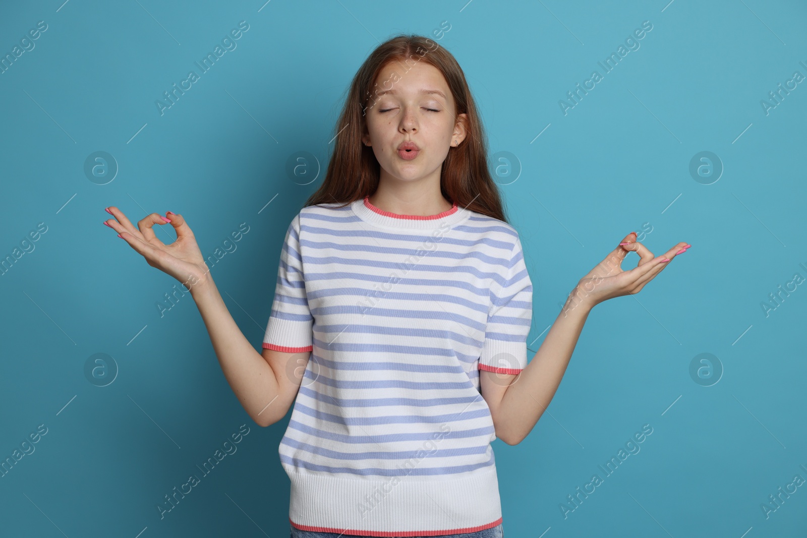 Teenage girl meditating on light blue background. Way to stop panic attack Photo of Teenage girl meditating on light blue background. Way to stop panic attack