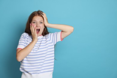 Photo of Teenage girl suffering from panic attack on light blue background. Space for text