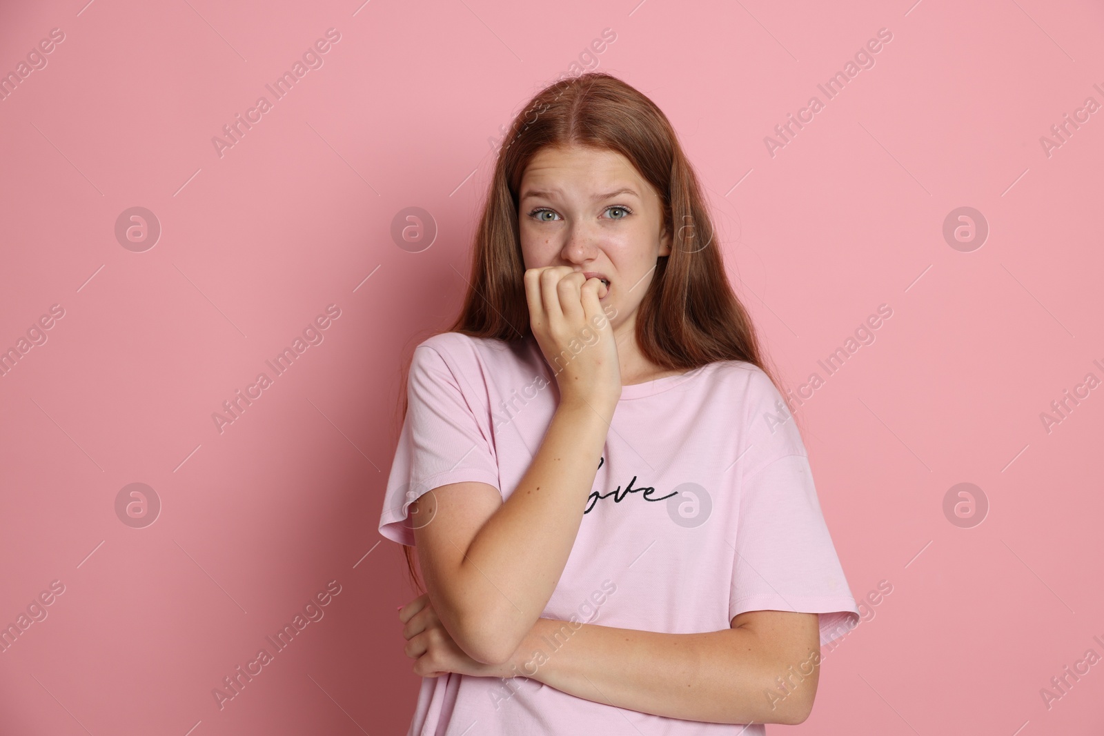 Photo of Teenage girl suffering from panic attack on pink background