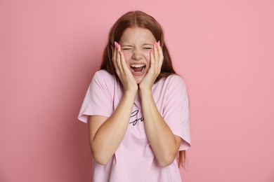 Photo of Teenage girl suffering from panic attack on pink background