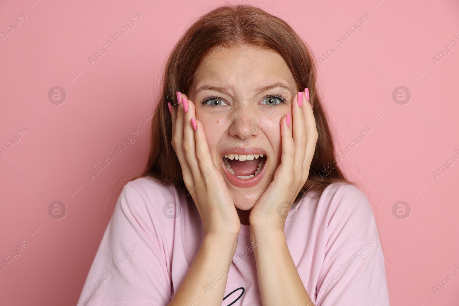 Photo of Teenage girl suffering from panic attack on pink background